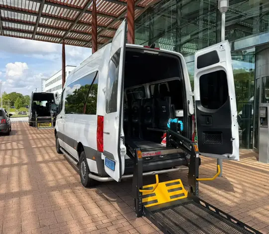 Professionele rolstoeltaxi chauffeur helpt klant in Gouda